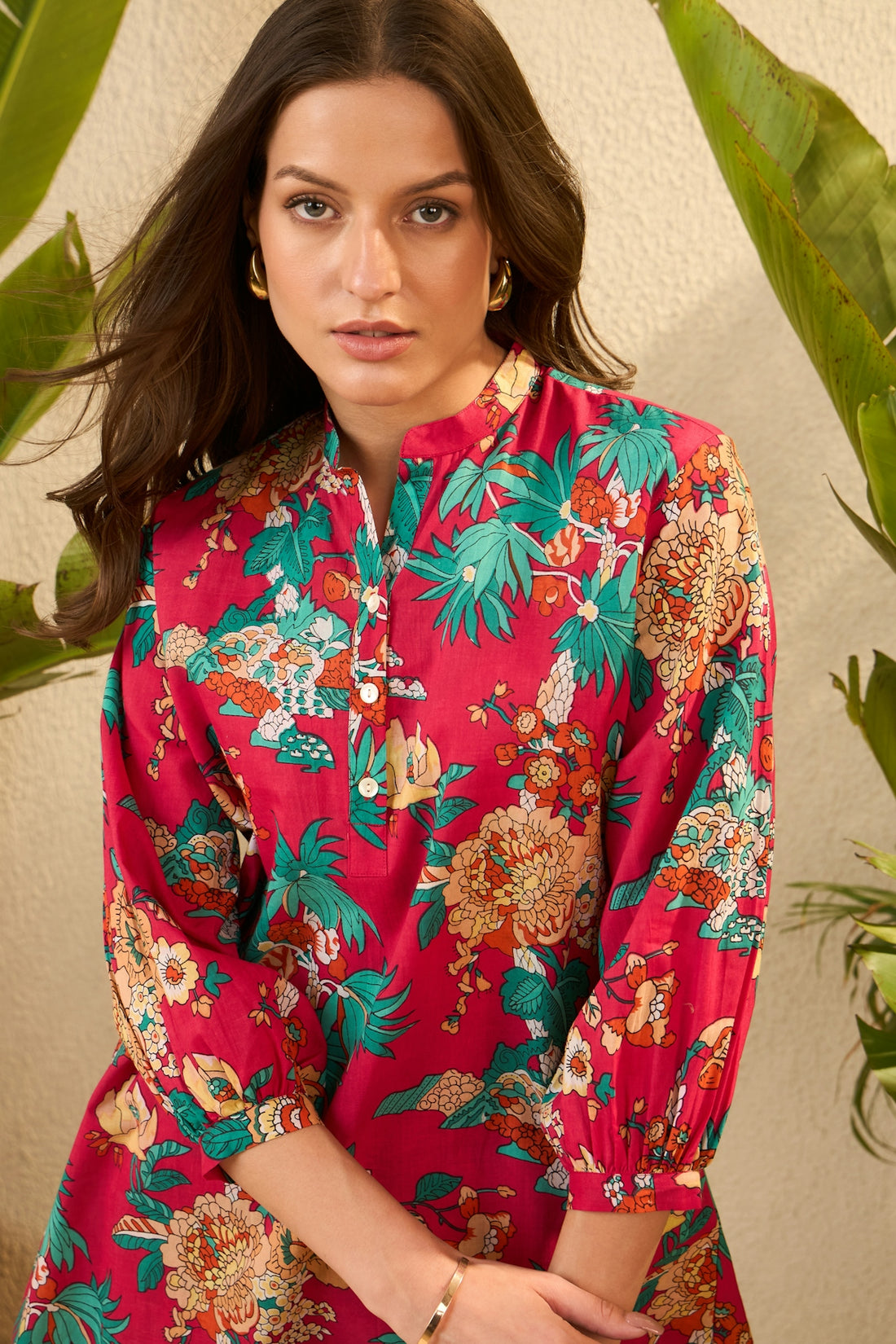 A woman in a vibrant floral print dress.