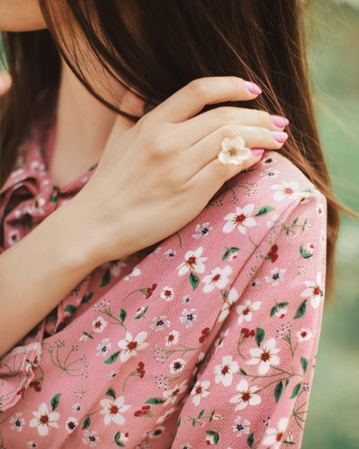 Woman wearing a floral dress with a flower ring
