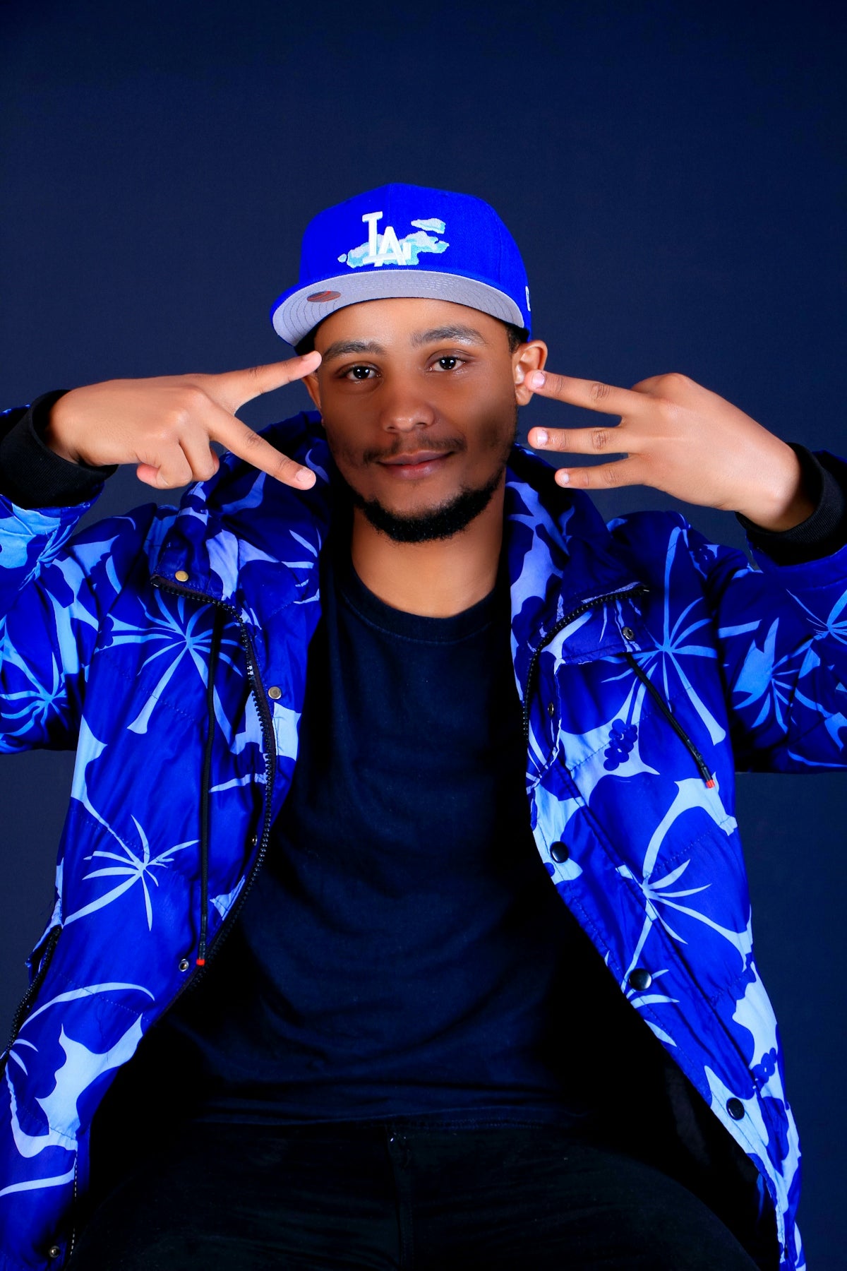 Man in blue floral jacket and baseball cap